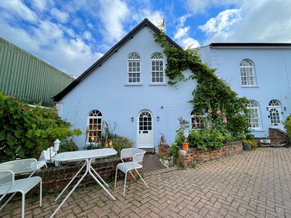 Spike Spondike’s house on the Isle of Wight. Robin blue house with patio table and chairs out front.